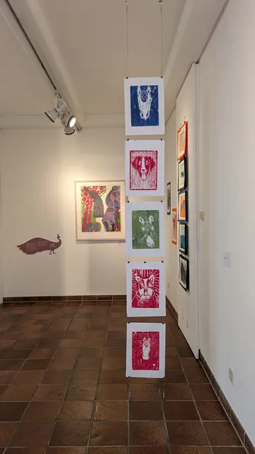 Drucke im Vordergrund: Hohenlohe-Gymnasium Öhringen 
Im Hintergrund: 
HAP Grieshaber, Baumblüte - die Frau mit Pfau, 1963
Holzschnitt, Sammlung Würth, Inv. 4154 © VG Bild-Kunst, Bonn 2025  | Foto: Eigene Aufnahme 