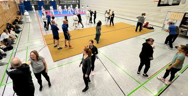 Partnerübungen im Selbstverteidigungskurs (im Hintergrund die Karatekas beim Training) | Foto: Karateverein Eppingen