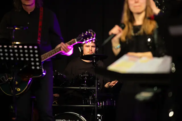 Ein Ausschnitt der Live-Band, man sieht die den Gitarrenspieler mit Gitarre und den Schlagzeuger