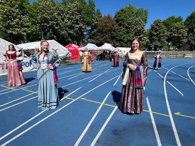 Mädchen in historischen Kostümen warten in einem Stadion.
