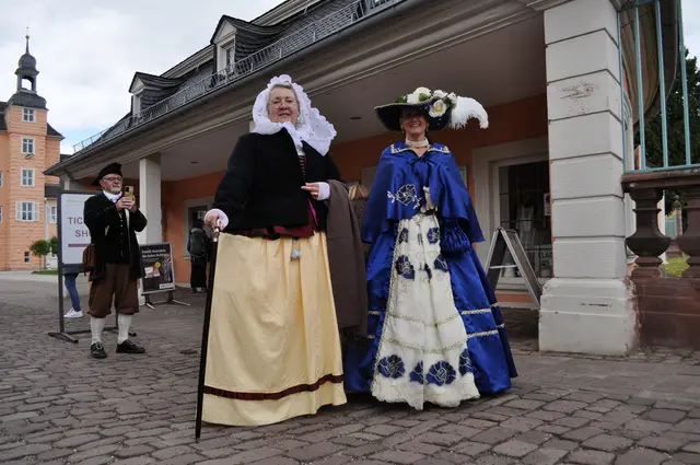 Historisch gekleidete Gästeführerinnen vor dem Schlosseingang Schwetzingen