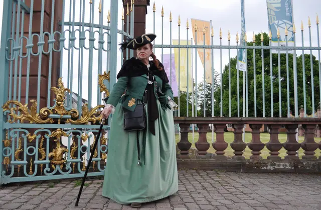 Historisch gekleidete Gästeführerin vor dem Schlosseingang Schwetzingen