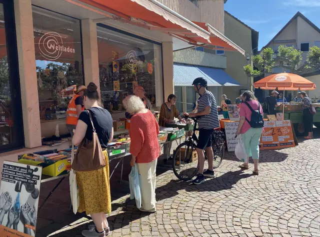 Die dargebotenen Bücher auf Tischen vor dem Weltladen und einem Traktoranhänger (im Hintergrund)  | Foto: Klaus Ries-Müller