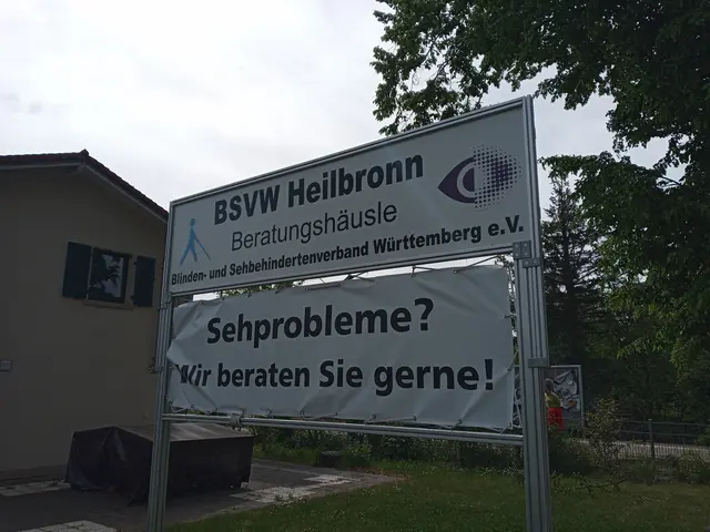 Das Bild zeigt das Schild im Garten des Beratungshäusle am Sonnenbrunnen. Oben steht zwischen dem Logo mit dem Männle mit dem Blindenstock und den neunen Logo des DBSV mit dem lila Auge der Text: BSVW Heilbronn Beratungshäusle und darunter Blinden und Sehbehindertenverband Württemberg e.V. Auf einem Banner darunter steht der Text: "Sehprobleme? Wir beraten Sie gern!