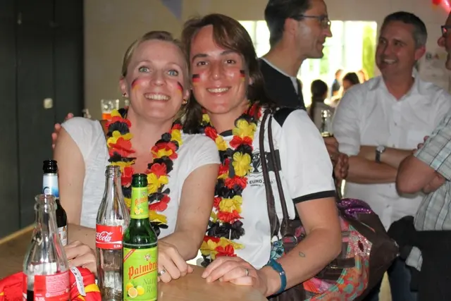 Frauen mit rot-schwarz-goldenen Hawaiketten um den Halst. 