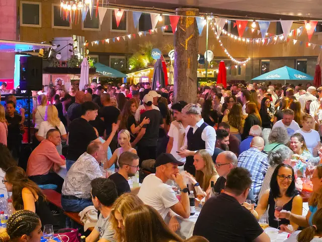 Abendstimmung mit vielen Menschen, die auf Bierbänken sitzen