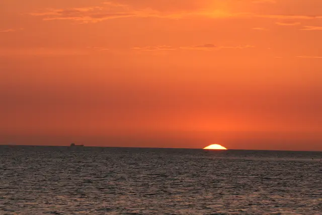 Sonnenuntergang am Öresund / Schweden, der Himmel ist glutorange, die Sonne versinkt im Meer.