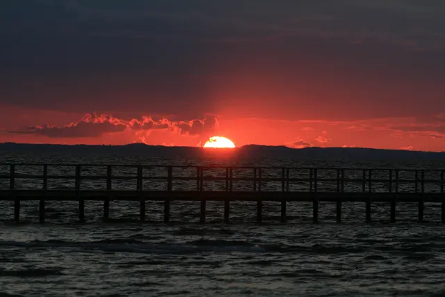 Sonnenuntergang vor einer Seebrück in Schweden mit magischem roten Himmel