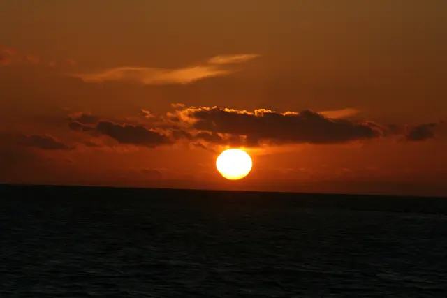 Sonnenuntergang am Öresund / Schweden. Die Sonne versinkt im Meer und bewölktem Himmel.