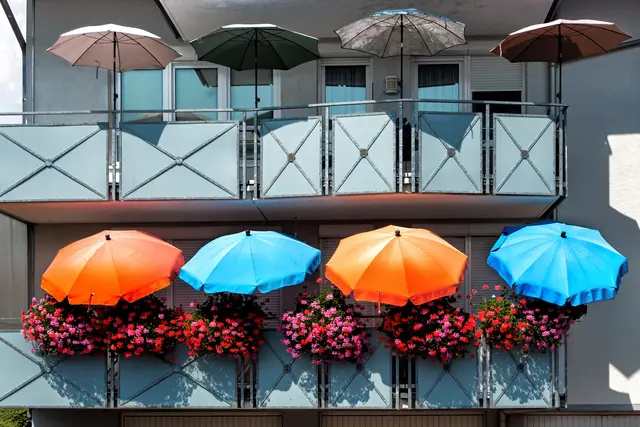 Ein Balkon ist eine schöne Sache aber bei großer Sommerhitze und Sonneneinstrahlung ist es notwendig sich davor zu schützen. Dies haben die Bewohner mit ihren farbenfrohen Sonnenschirmen eindrucksvoll umgesetzt. | Foto: Rüdiger Reingräber